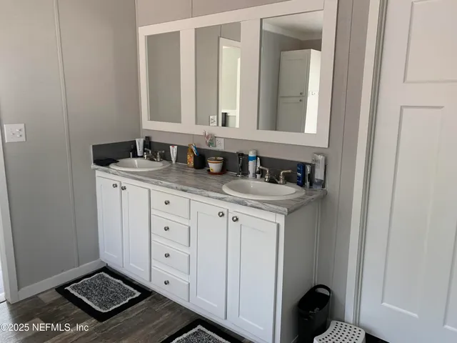 a bathroom with a granite countertop sink and a mirror