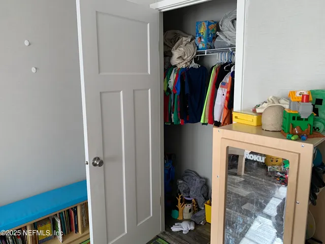 a view of walk in closet with clothes and shoes