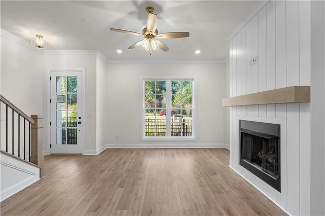 a large white kitchen with a refrigerator a sink and wooden floor