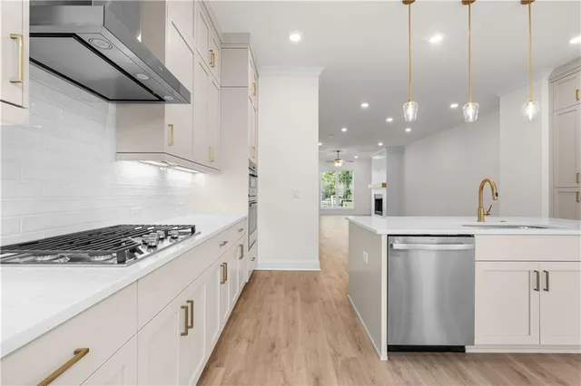 a kitchen with a sink chandelier and white cabinets