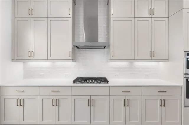 a open kitchen with white cabinets and wooden floor