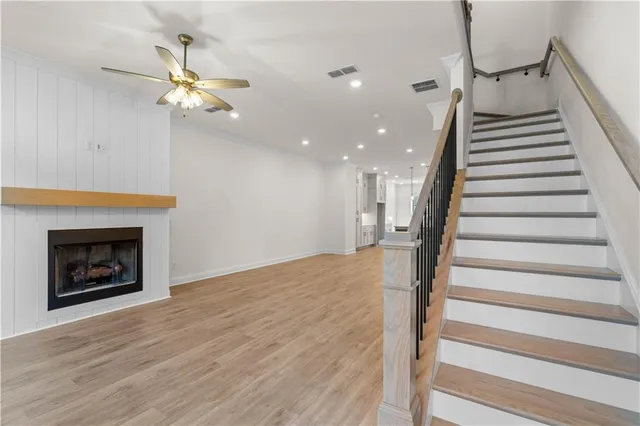 a view of a livingroom with wooden floor and a fireplace