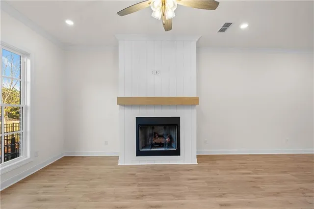 an empty room with fireplace and wooden floor