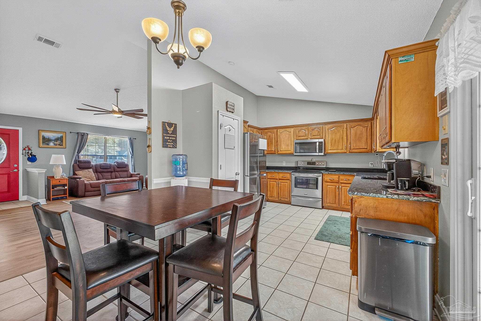 5361 Willard Norris Road Milton, FL 32570 - Photo 12 of 51 a kitchen with stainless steel appliances granite countertop a sink a stove a dining table and chairs