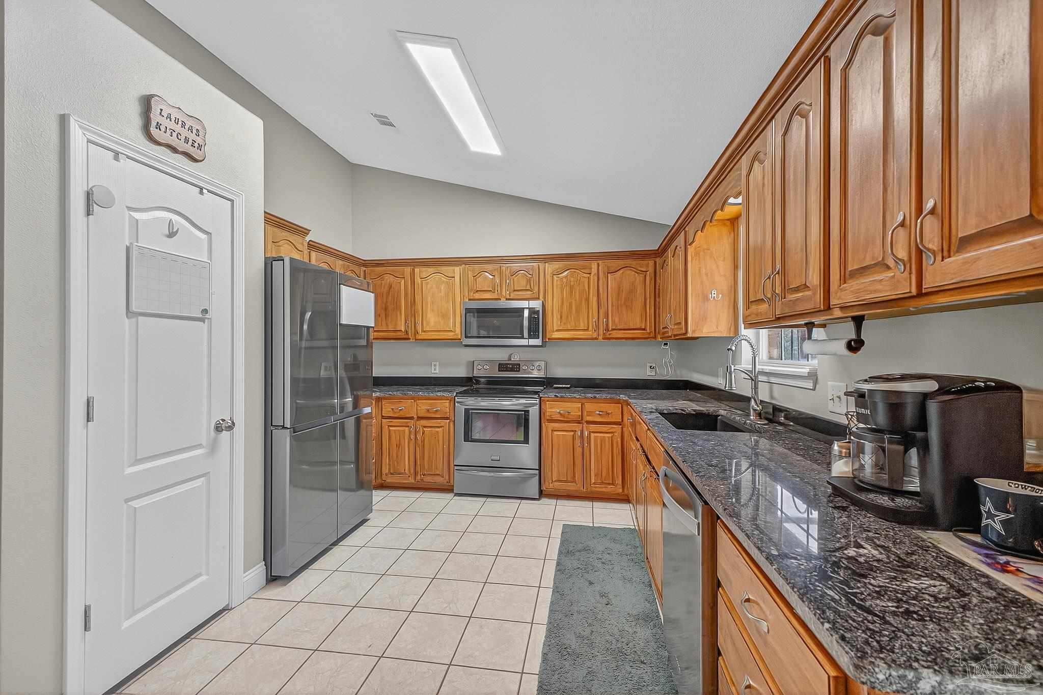 5361 Willard Norris Road Milton, FL 32570 - Photo 13 of 51 a kitchen with stainless steel appliances granite countertop a stove a sink and a refrigerator
