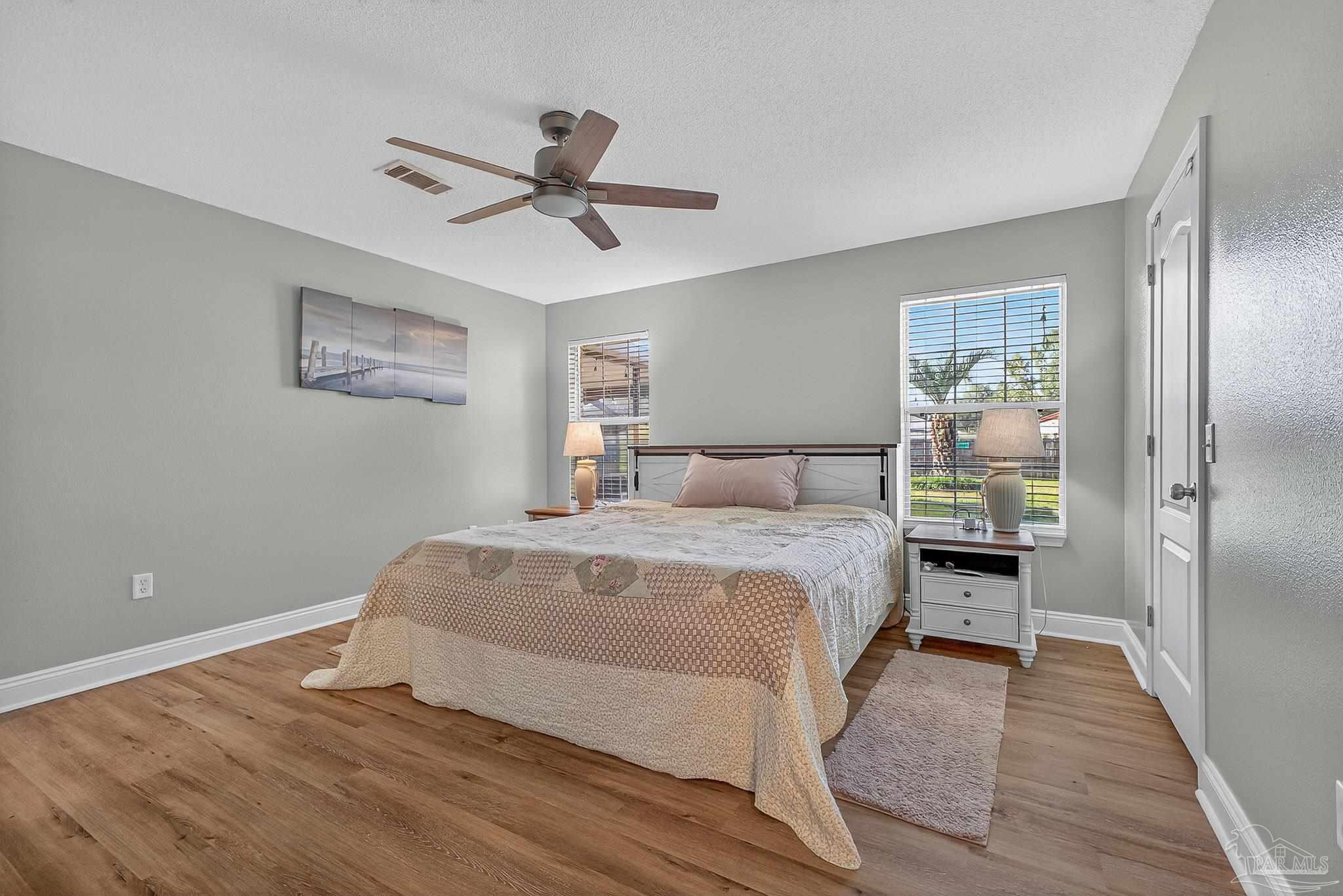 5361 Willard Norris Road Milton, FL 32570 - Photo 23 of 51 a bedroom with a bed and wooden floor