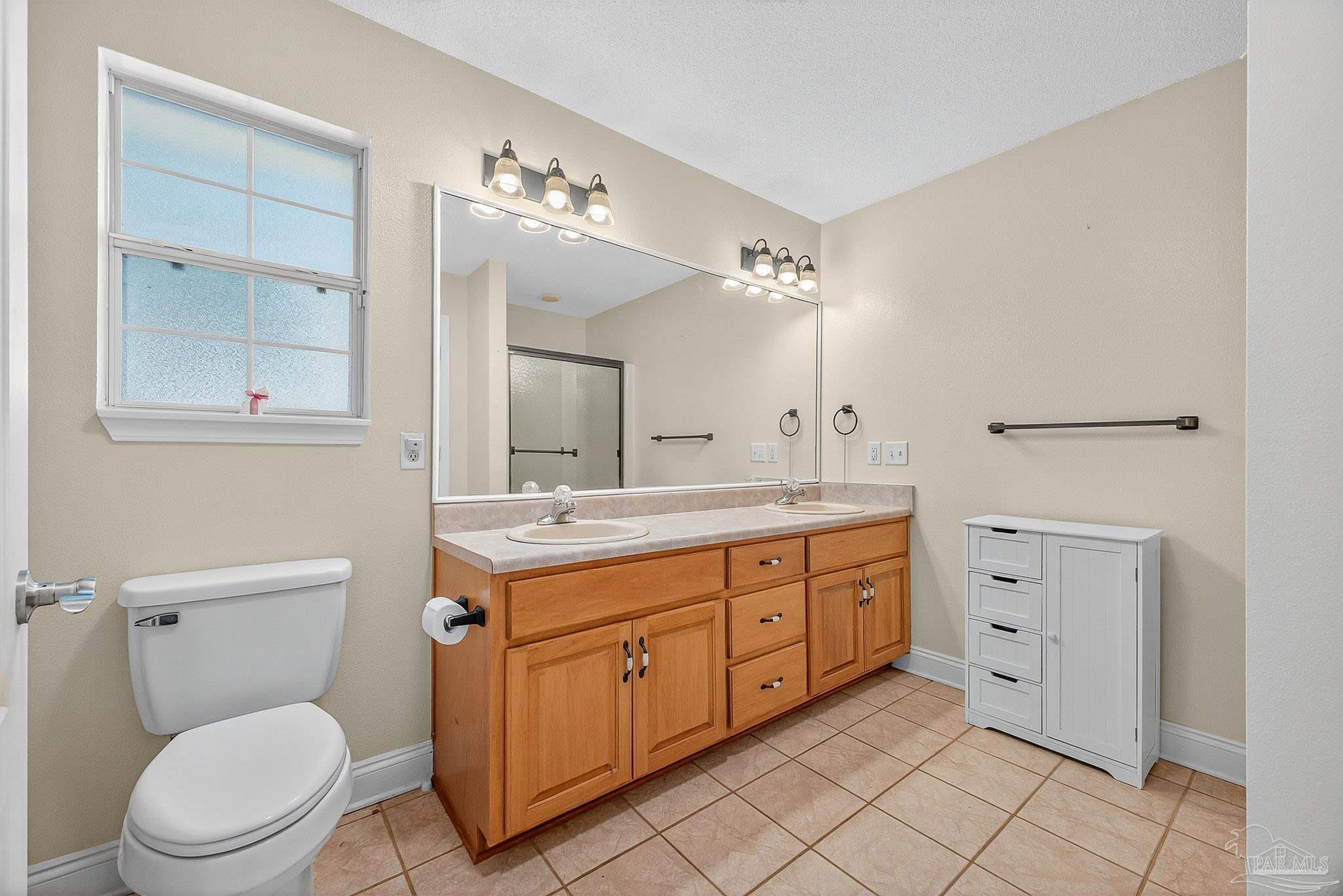 5361 Willard Norris Road Milton, FL 32570 - Photo 25 of 51 a spacious bathroom with a toilet sink and mirror