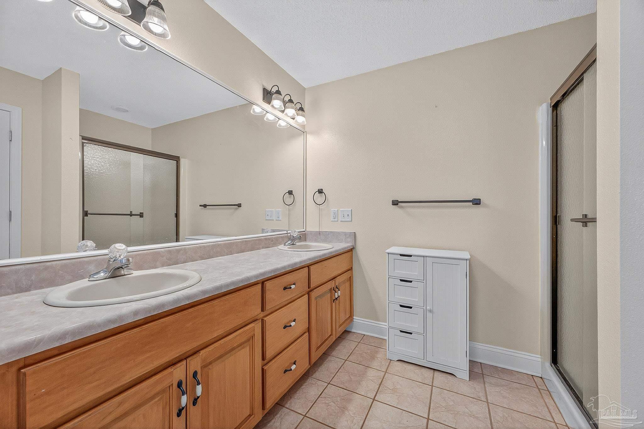 5361 Willard Norris Road Milton, FL 32570 - Photo 26 of 51 a spacious bathroom with a double vanity sink a mirror and a shower