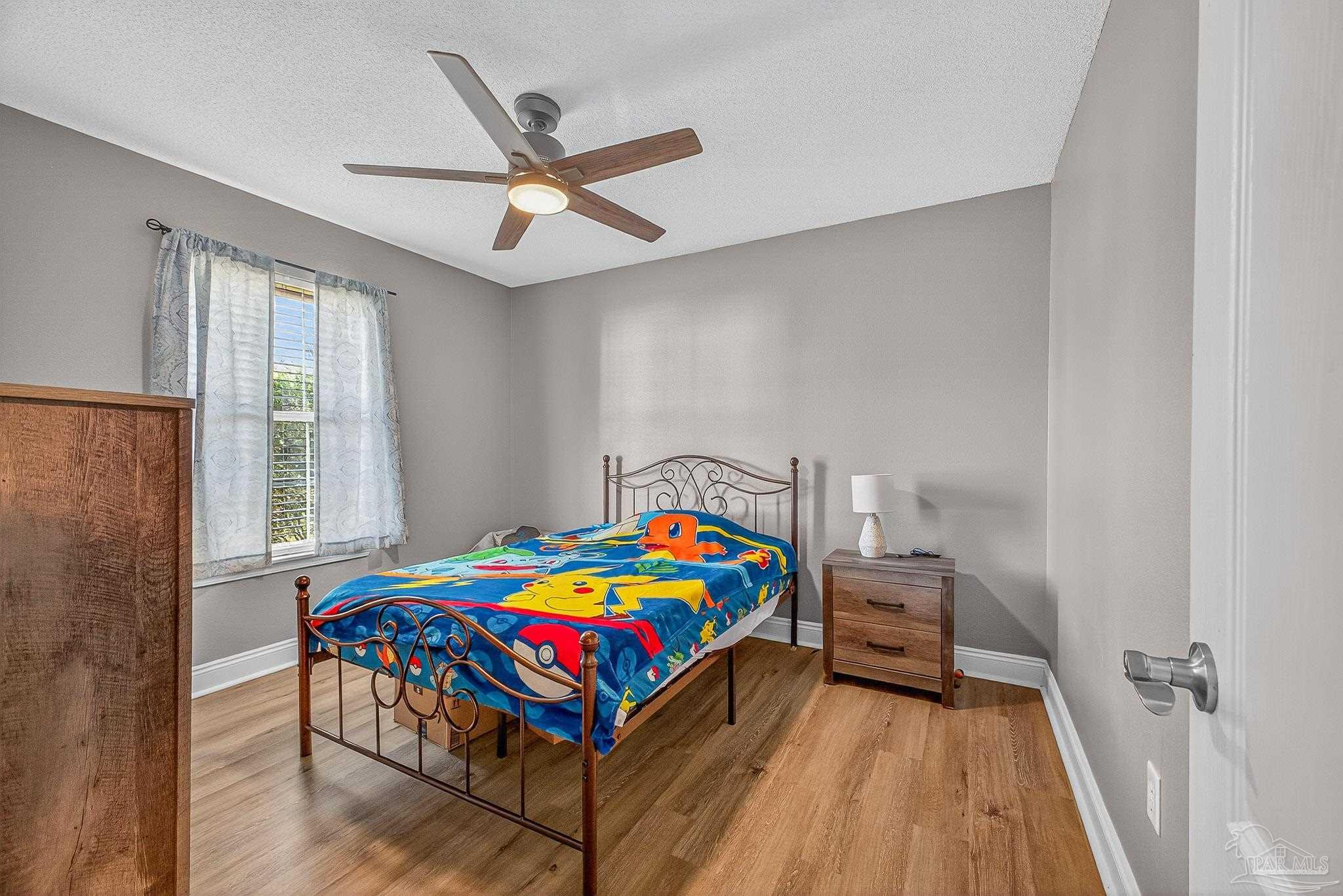 5361 Willard Norris Road Milton, FL 32570 - Photo 30 of 51 a bedroom with a bed and a chandelier