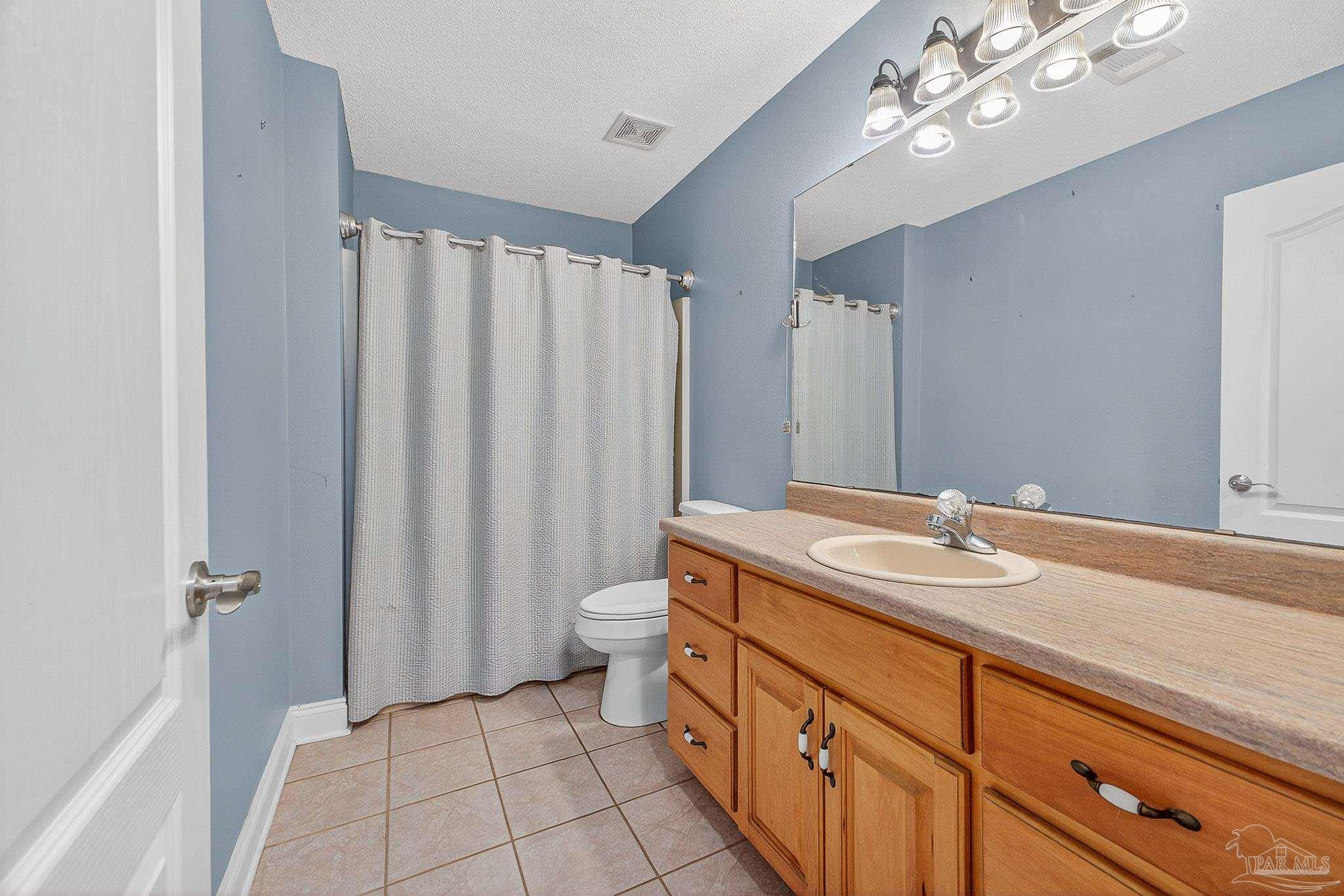 5361 Willard Norris Road Milton, FL 32570 - Photo 33 of 51 a spacious bathroom with a granite countertop sink a toilet and a mirror