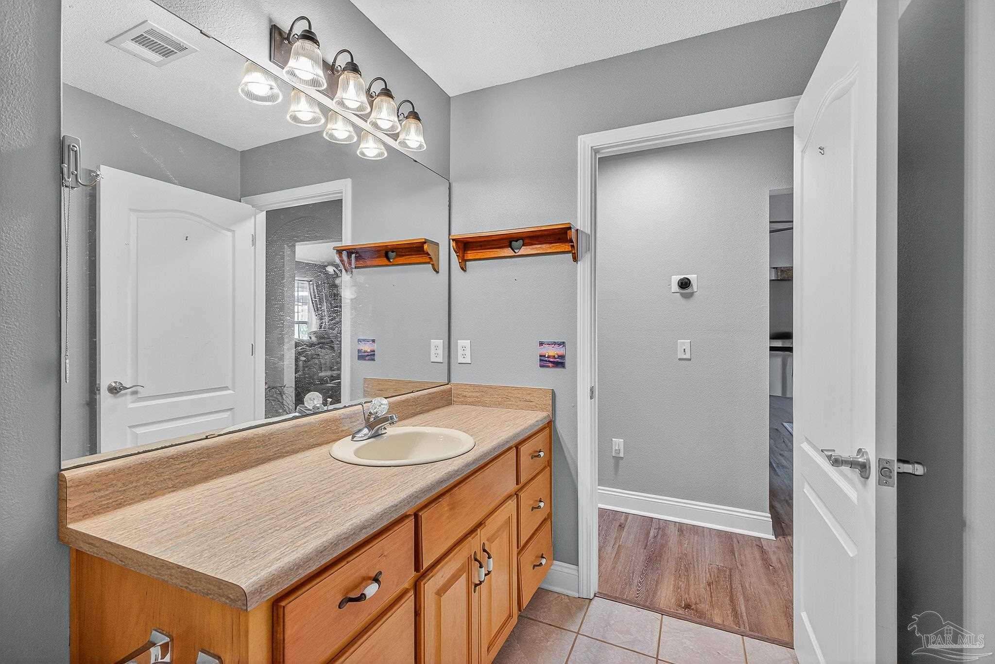 5361 Willard Norris Road Milton, FL 32570 - Photo 34 of 51 a bathroom with a sink a faucet a mirror and a shower