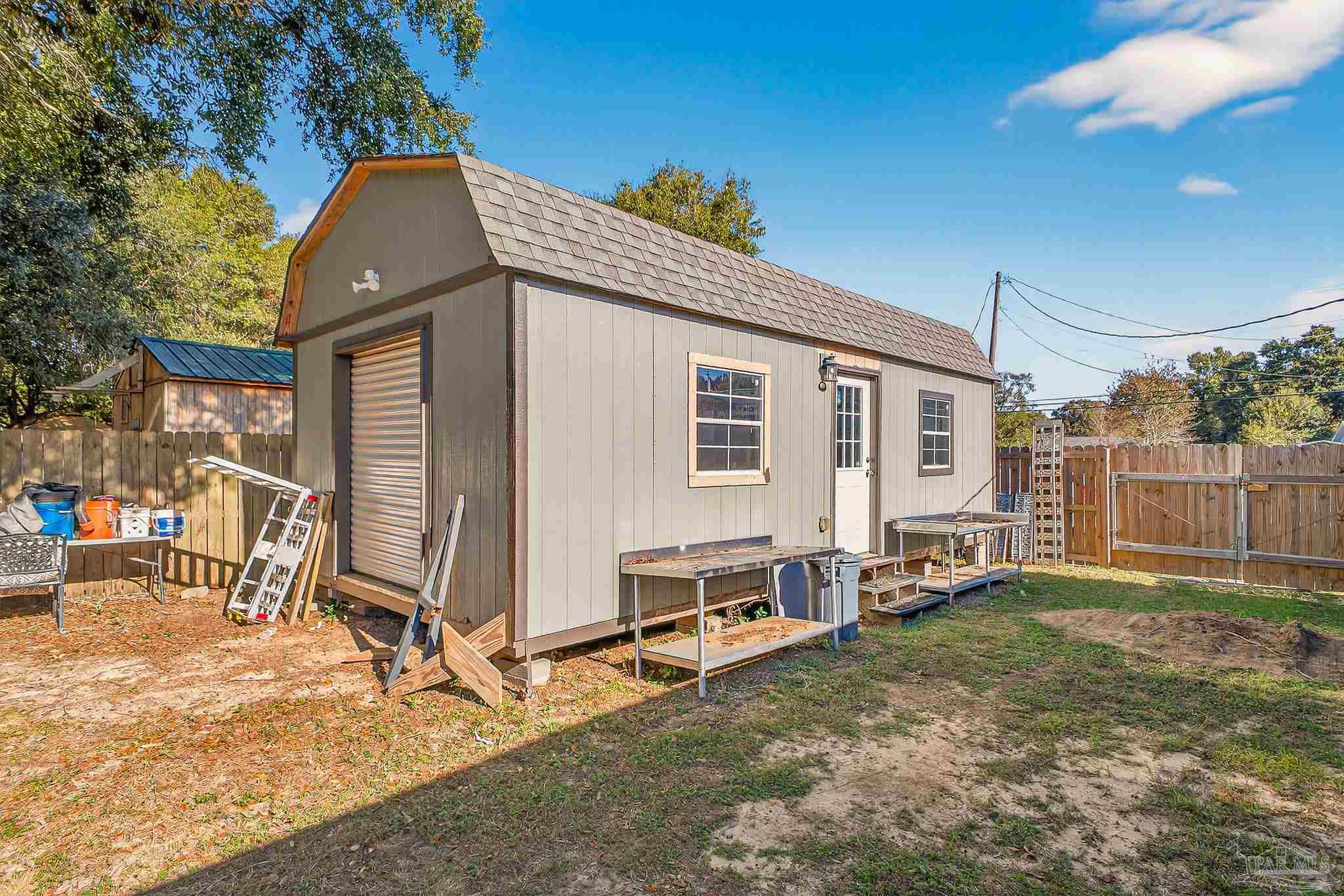 5361 Willard Norris Road Milton, FL 32570 - Photo 44 of 51 a backyard of a house with barbeque oven table and chairs
