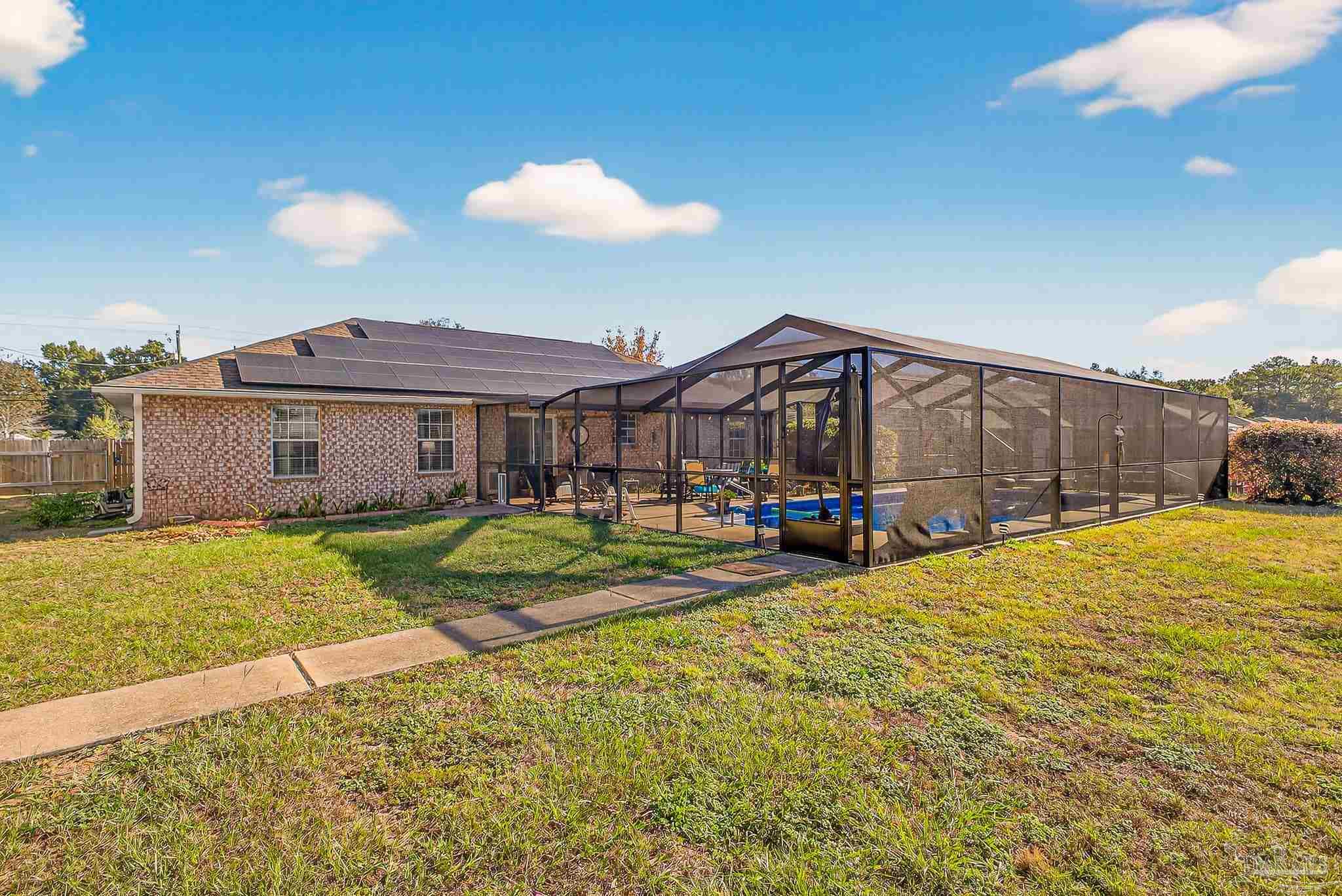 5361 Willard Norris Road Milton, FL 32570 - Photo 46 of 51 a view of a house with a yard and table and chairs under an umbrella