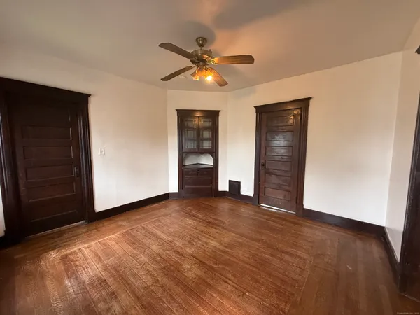 a view of an empty room with a ceiling fan and a window