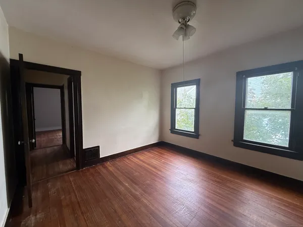 a view of an empty room with wooden floor