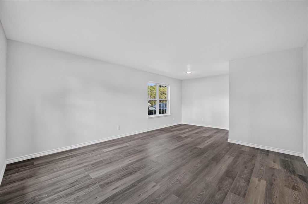 1801 East Grauwyler Road, Unit 101 Irving, TX 75061 - Photo 28 of 39 an empty room with wooden floor and windows