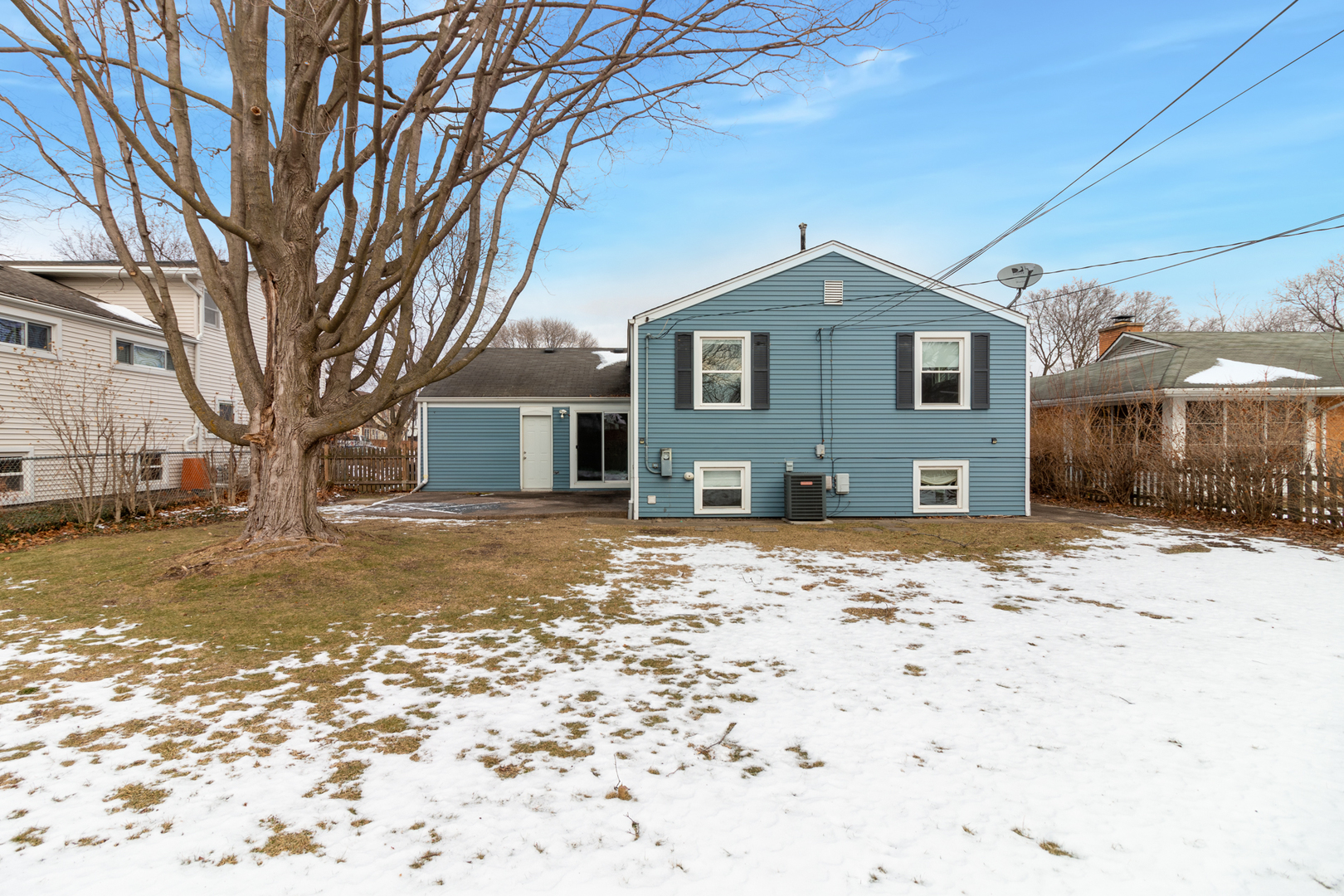 1005 West Pendleton Place Mount Prospect, IL 60056 - Photo 19 of 24 a front view of a house with a yard covered in snow