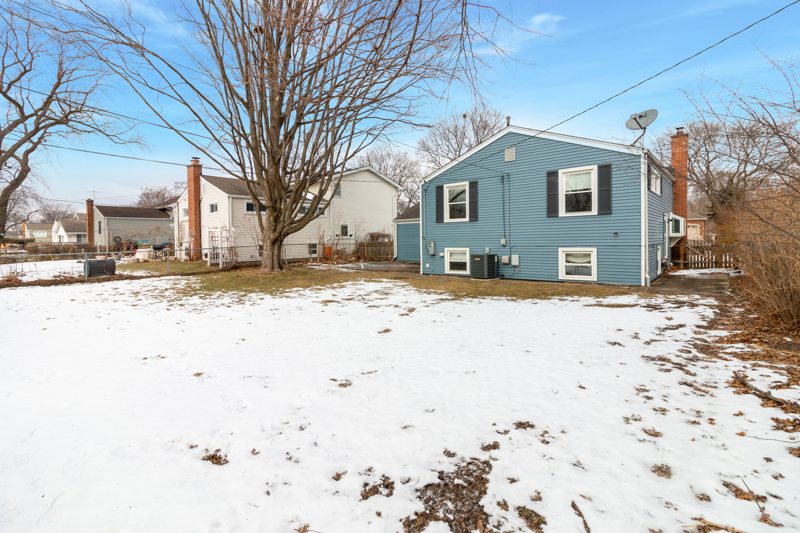 1005 West Pendleton Place Mount Prospect, IL 60056 - Photo 20 of 24 a front view of a house with a yard covered in snow