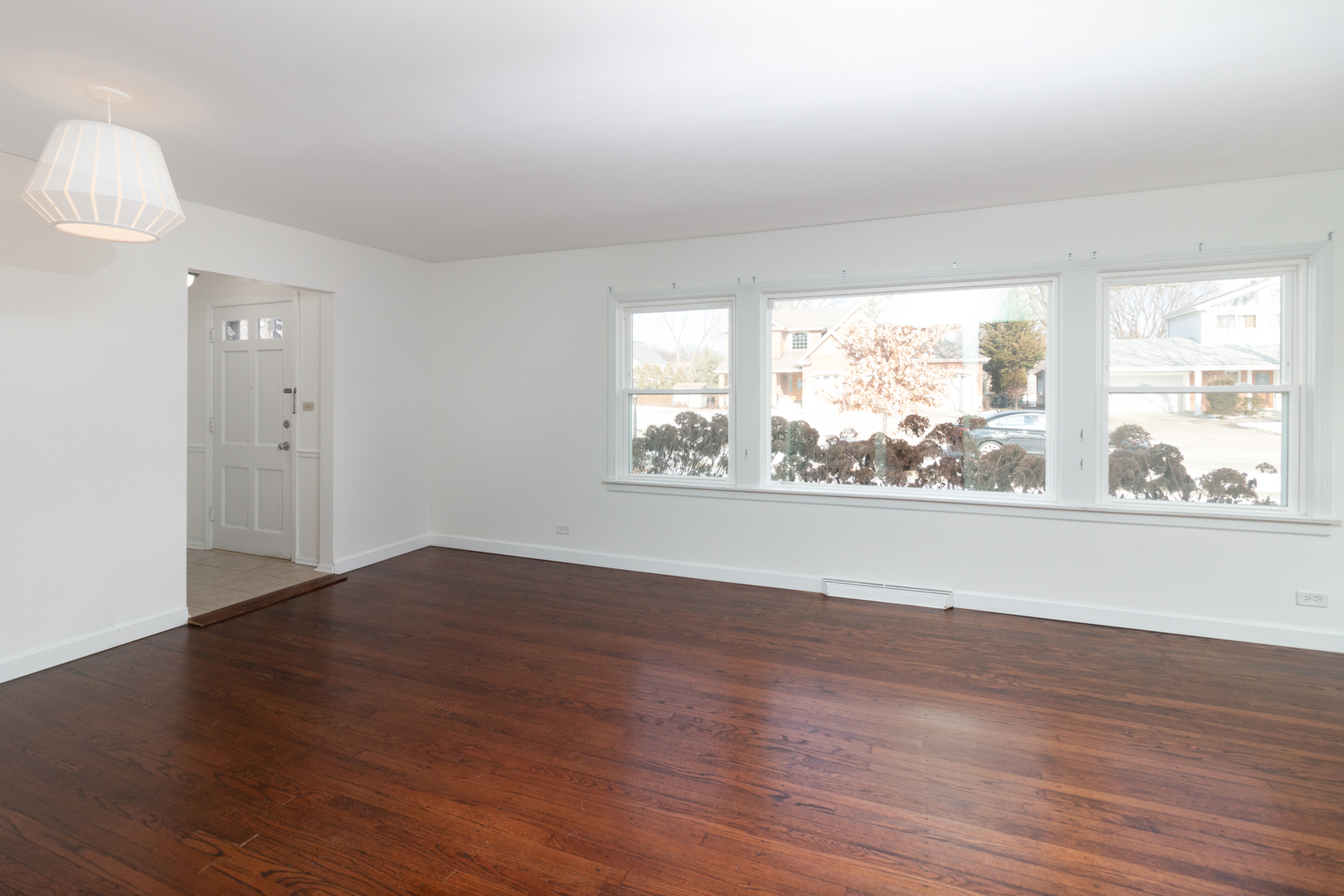 1005 West Pendleton Place Mount Prospect, IL 60056 - Photo 5 of 24 an empty room with wooden floor and windows