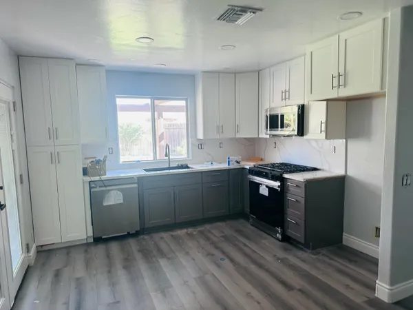 a large kitchen with a stove a sink dishwasher and a refrigerator