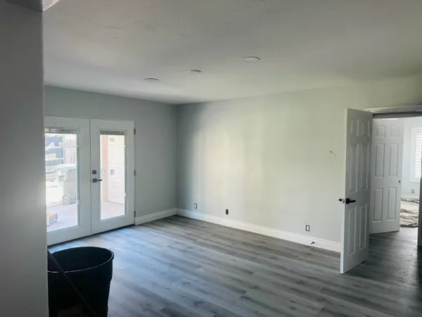 an empty room with wooden floor and windows