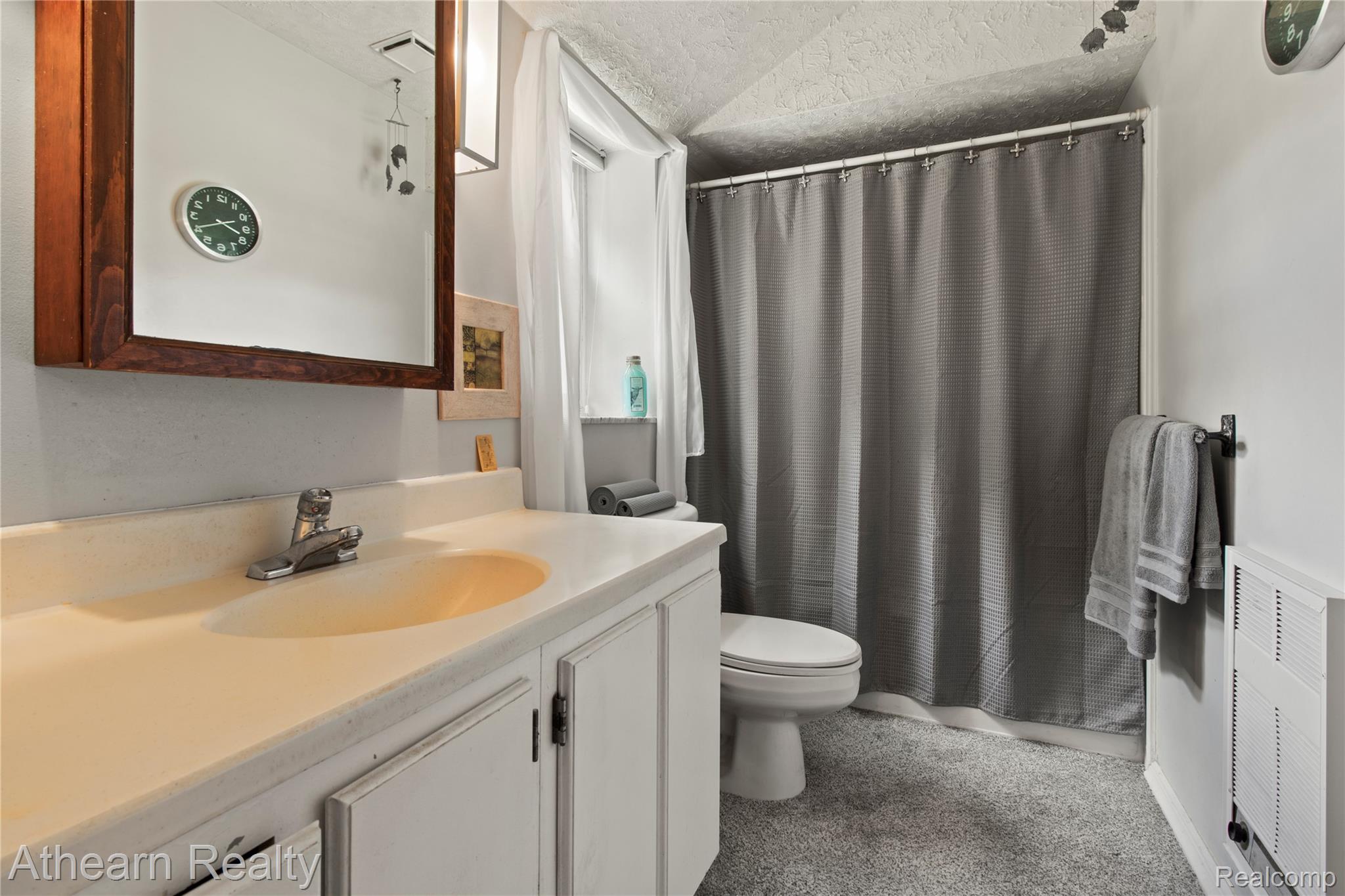 12427 Foley Road Fenton, MI 48430 - Photo 41 of 47 Bathroom featuring a white vanity with an integrated sink, a dark wood-framed mirror, and a white toilet