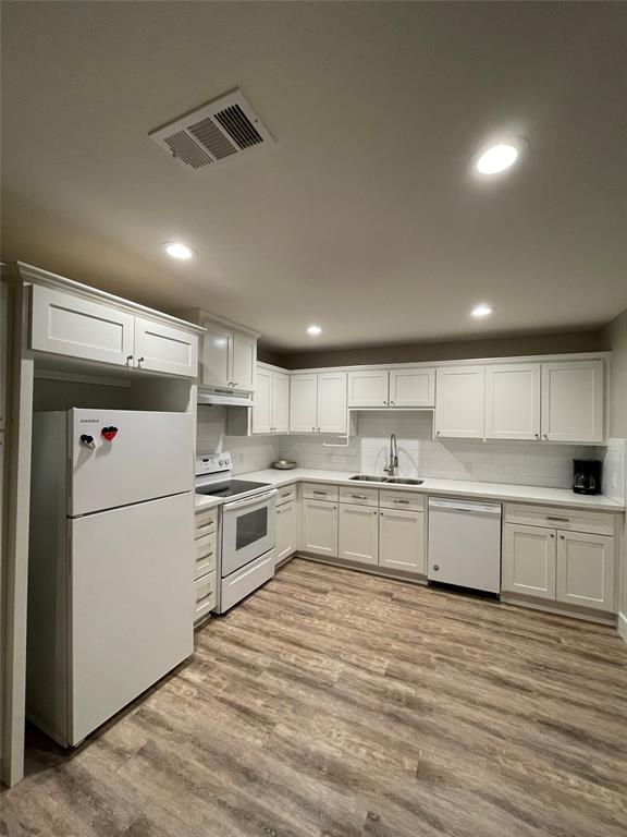 a large white kitchen with stainless steel appliances granite countertop a stove and a refrigerator