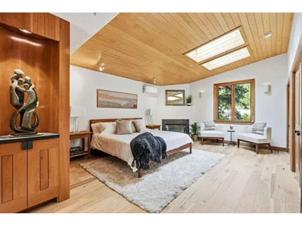 a spacious bedroom with a bed and wooden floor