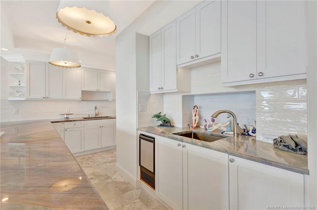 2001 Southeast Sailfish Point Boulevard, Unit 303 Stuart, FL 34996 - Photo 12 of 63 a kitchen with stainless steel appliances granite countertop a sink a stove and cabinets