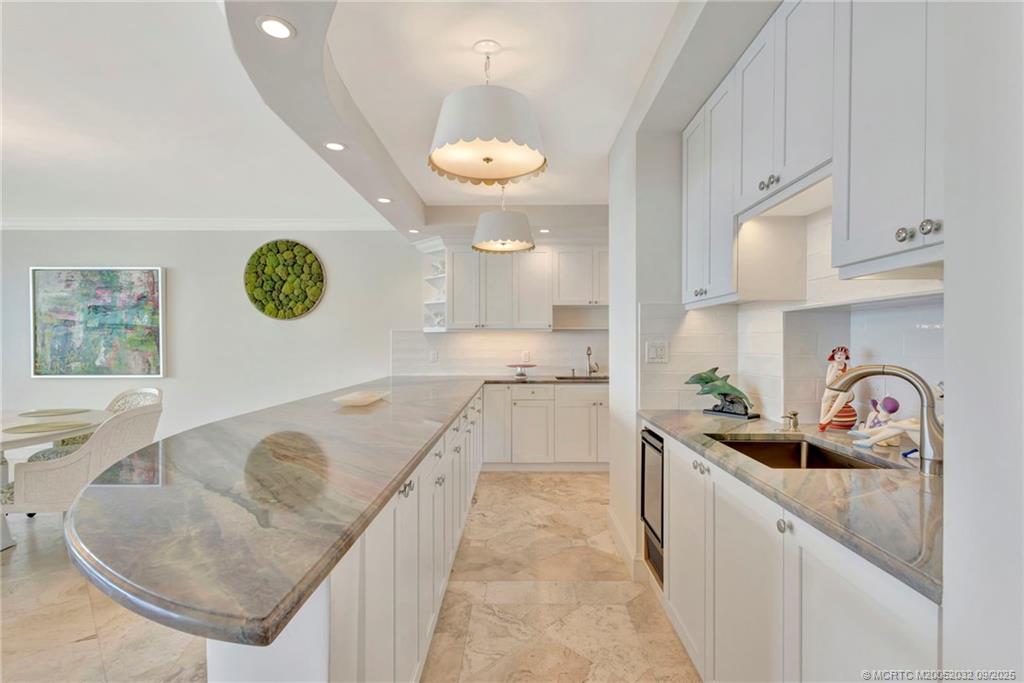 2001 Southeast Sailfish Point Boulevard, Unit 303 Stuart, FL 34996 - Photo 13 of 63 a kitchen with cabinets a sink and a stove