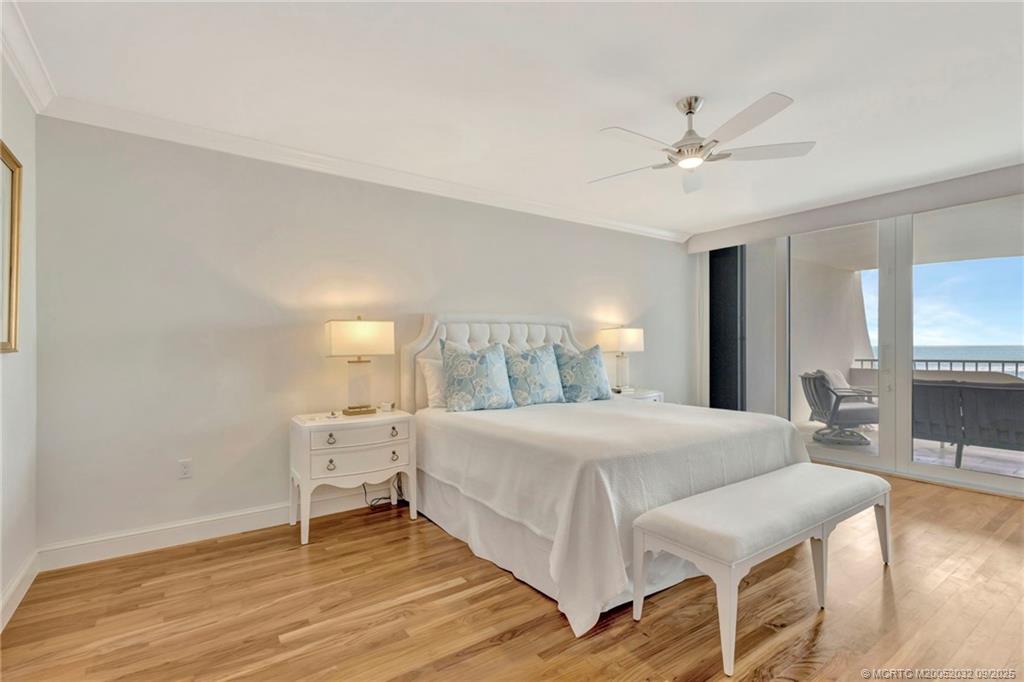 2001 Southeast Sailfish Point Boulevard, Unit 303 Stuart, FL 34996 - Photo 28 of 63 a bedroom with a bed and a chandelier