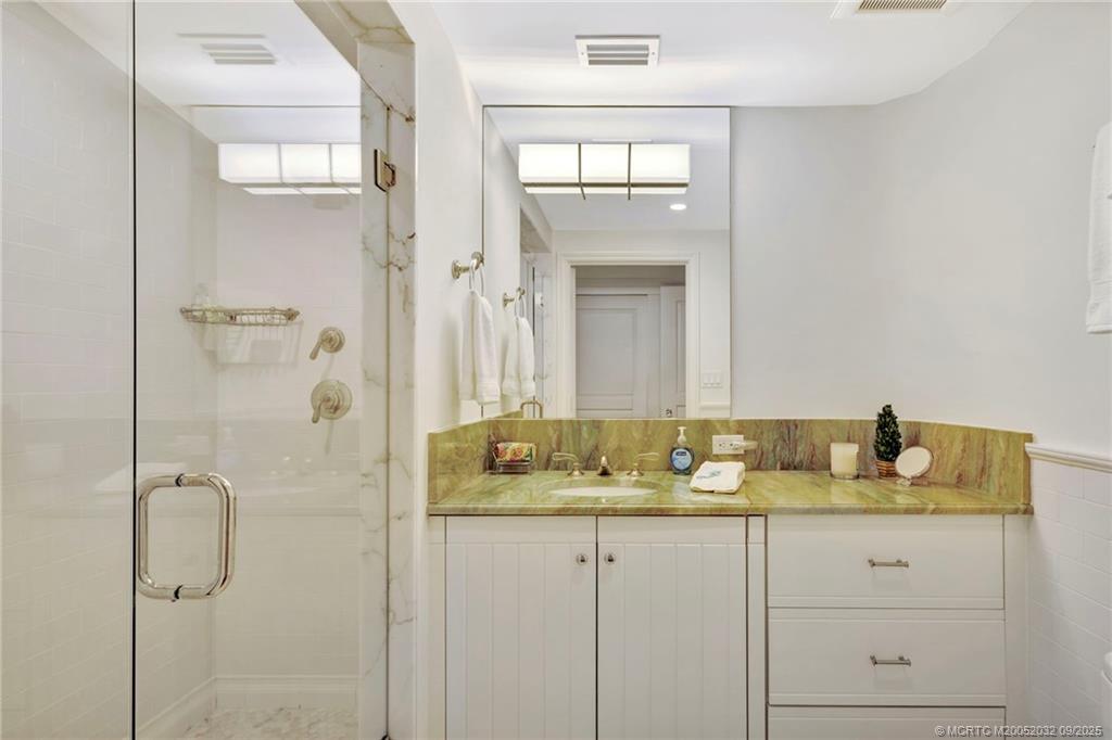 2001 Southeast Sailfish Point Boulevard, Unit 303 Stuart, FL 34996 - Photo 36 of 63 a bathroom with a granite countertop sink and a mirror