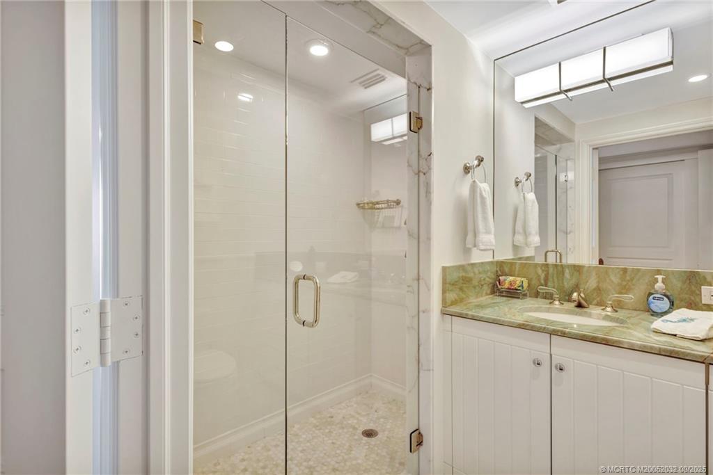 2001 Southeast Sailfish Point Boulevard, Unit 303 Stuart, FL 34996 - Photo 37 of 63 a bathroom with a granite countertop sink mirror and double