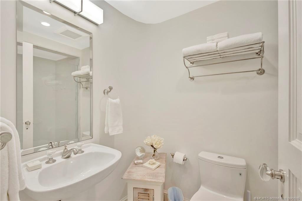 2001 Southeast Sailfish Point Boulevard, Unit 303 Stuart, FL 34996 - Photo 40 of 63 a bathroom with a sink mirror and toilet