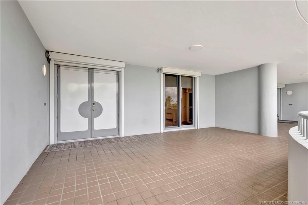 2001 Southeast Sailfish Point Boulevard, Unit 303 Stuart, FL 34996 - Photo 42 of 63 a view of an empty room with a fireplace and glass door