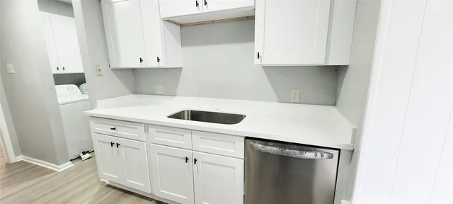 a kitchen with white cabinets and white appliances