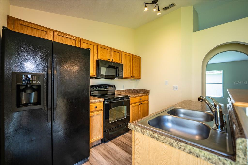 241 Grove Branch Road Winter Haven, FL 33880 - Photo 12 of 31 a kitchen with stainless steel appliances granite countertop a sink and a refrigerator