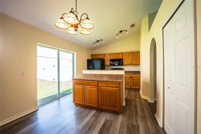 an empty room with wooden floor and fan