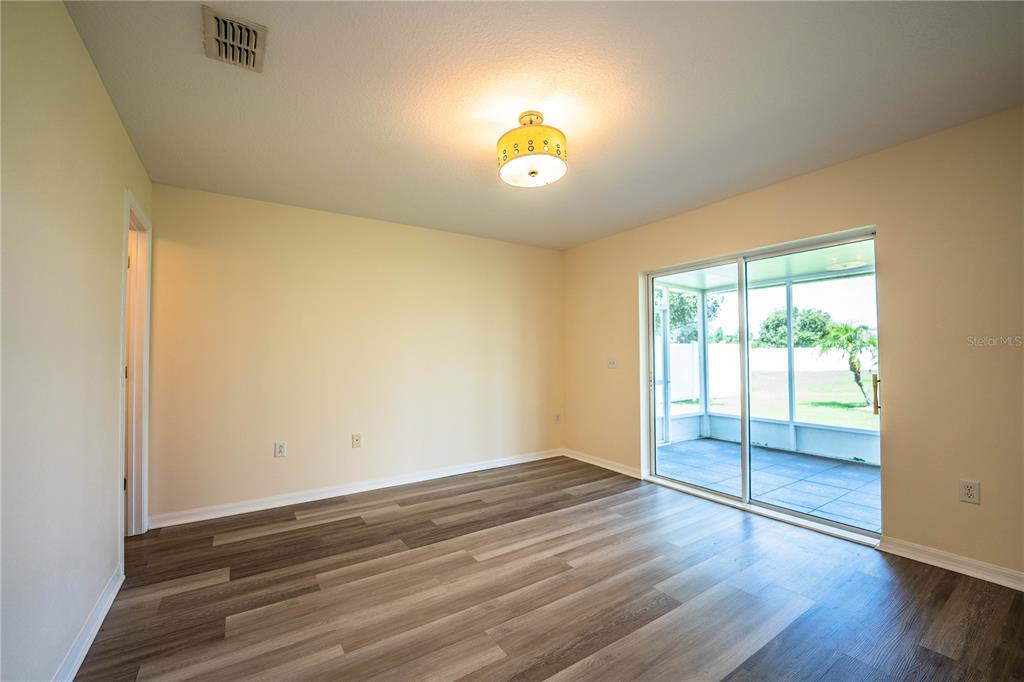 241 Grove Branch Road Winter Haven, FL 33880 - Photo 14 of 31 an empty room with wooden floor and fan