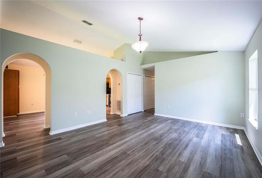 241 Grove Branch Road Winter Haven, FL 33880 - Photo 3 of 31 a view of an empty room with wooden floor window and a ceiling fan