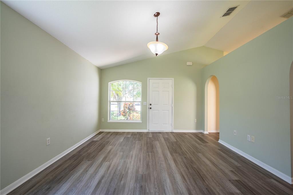 241 Grove Branch Road Winter Haven, FL 33880 - Photo 4 of 31 a view of an empty room with wooden floor and a window