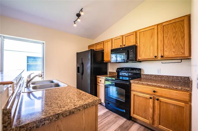 a kitchen with stainless steel appliances granite countertop a stove top oven a sink and dishwasher
