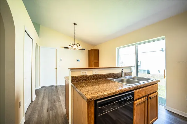a kitchen with granite countertop a sink and a stove