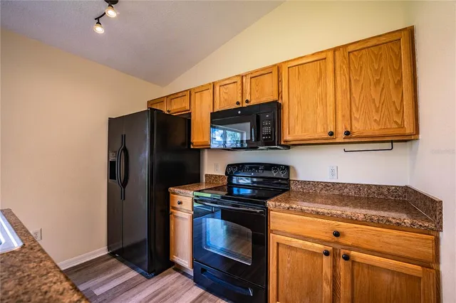 a kitchen with stainless steel appliances granite countertop a stove a microwave and a refrigerator