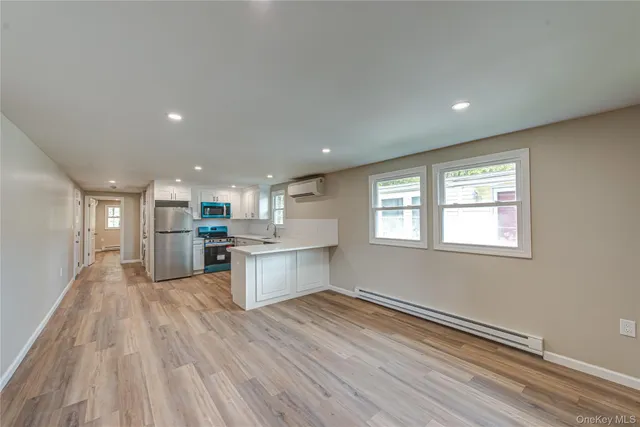 a kitchen with a refrigerator and wooden floor