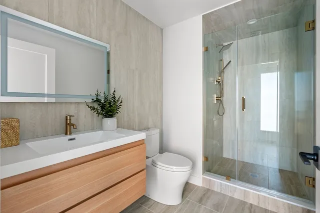 a bathroom with a sink a toilet and shower