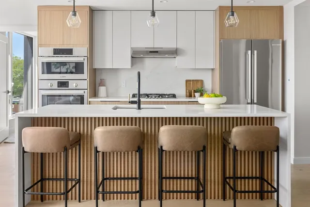 a kitchen with kitchen island granite countertop a table chair and cabinets