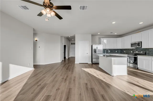a view of kitchen with sink microwave and refrigerator