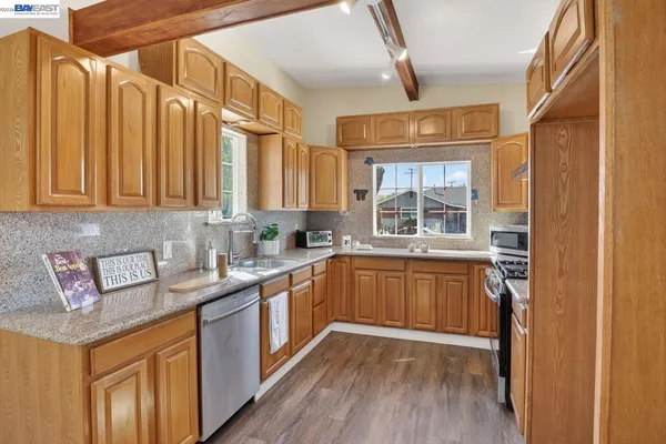 a kitchen with stainless steel appliances granite countertop a sink stove and cabinets
