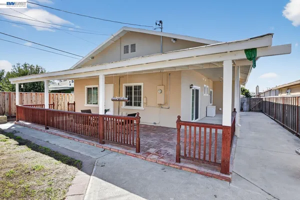 a view of a house with wooden deck and furniture